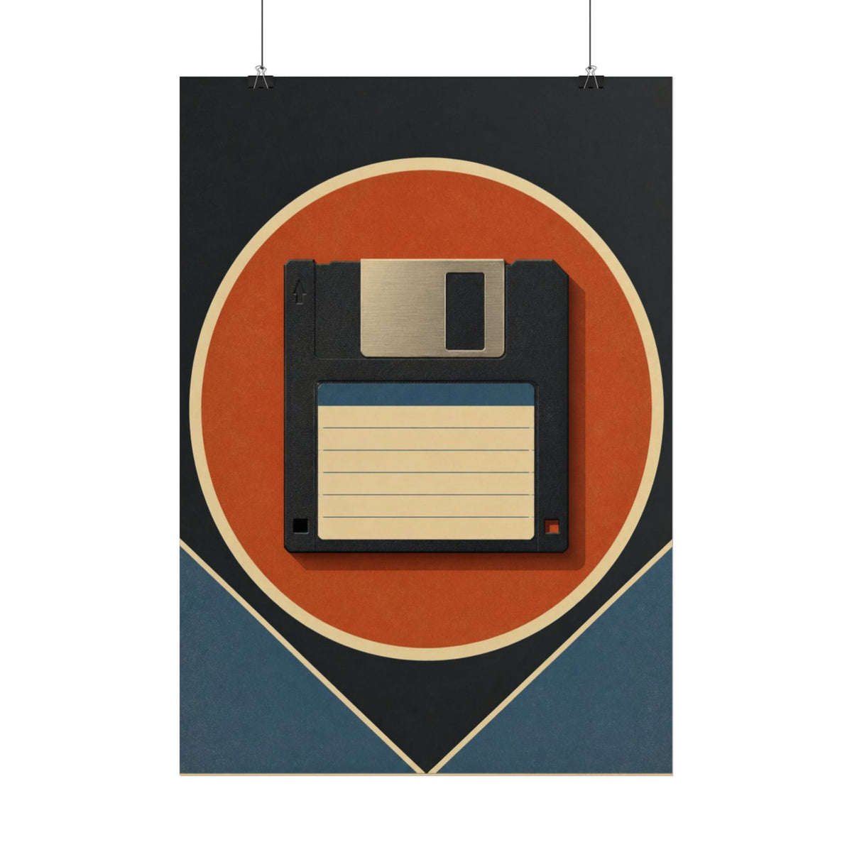 A framed wall art print featuring a retro 1980s floppy disk design hangs above a wooden desk in a styled home office setting with a keyboard, notebook, lamp, and plant.